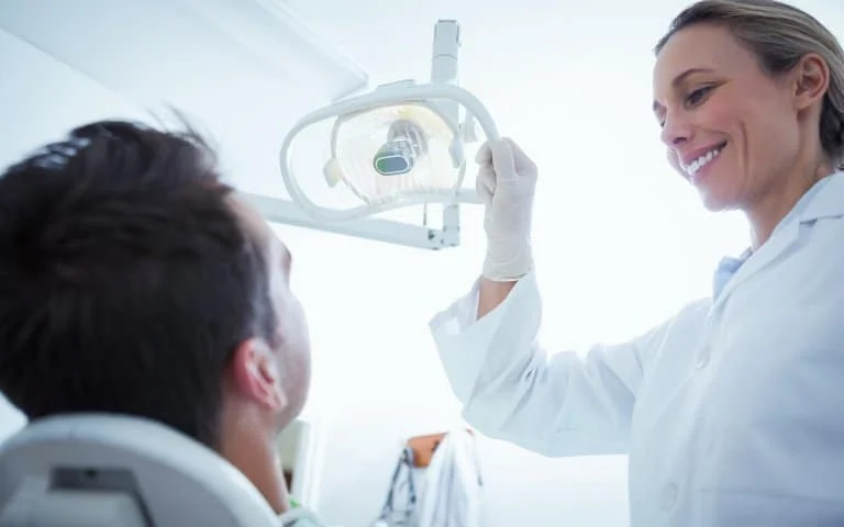 a woman holding a light up to a man
